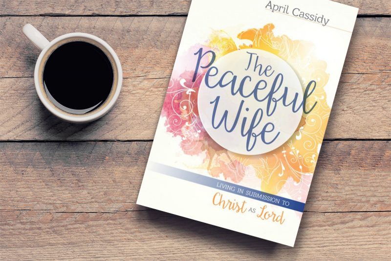 The Peaceful Wife book and a coffee mug on a wooden table