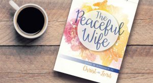 Picture of the Peaceful Wife book and a cup of coffee on a wooden table