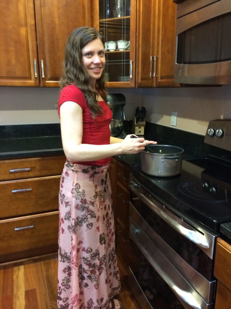 April Cassidy cooking at the stove in her kitchen.